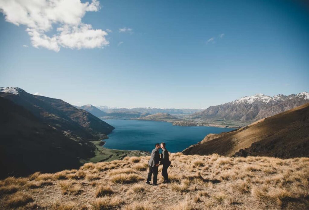 Grooms posing for wedding photo with a mountain backdrop
