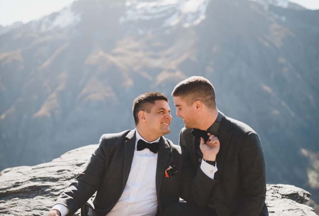 Grooms posing for wedding photo with a mountain backdrop