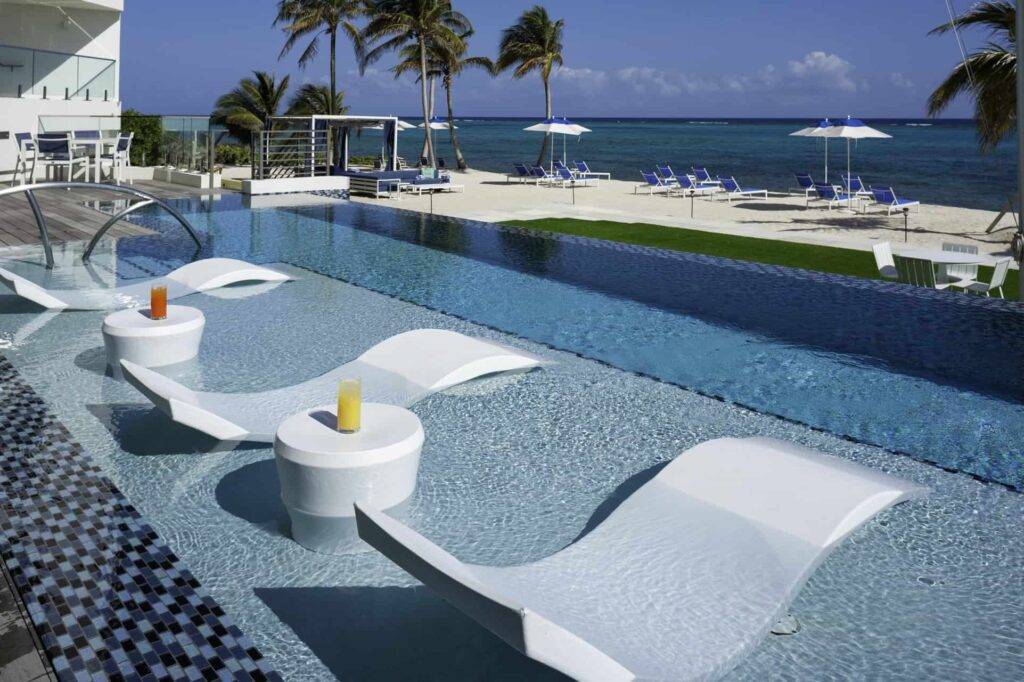 Rum Point Club infinity edge pool with in-water lounge chairs and drink tables.