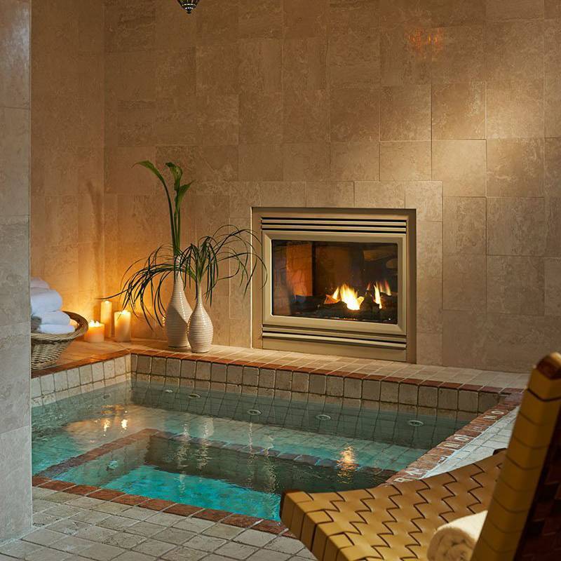 Hot tub and fireplace inside the Mirror Lake Inn Spa
