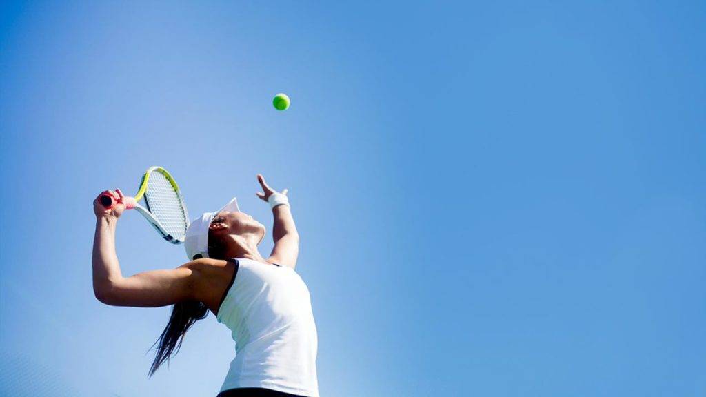 Woman about to serve a tennis ball