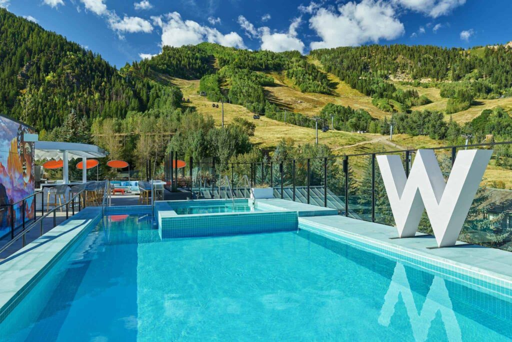 Sky Residences at W Aspen exterior pool and wet deck surrounded by lush green mountains.