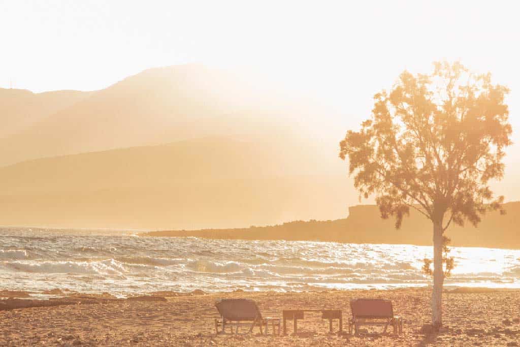 Liegestühle am Strand von Kreta bei Sonnenuntergang