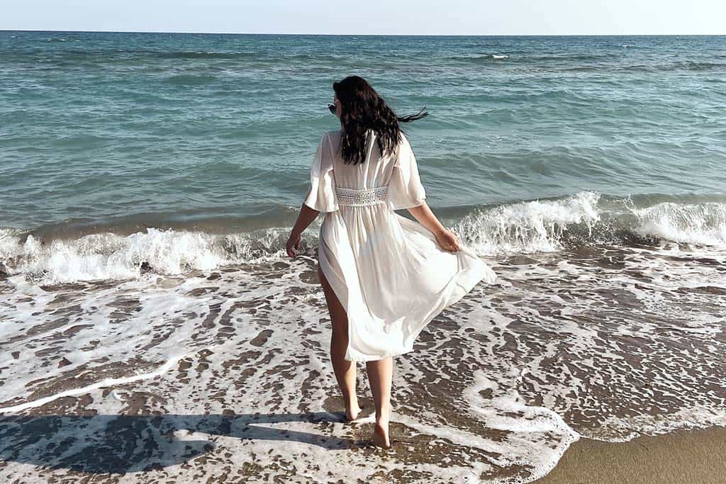 Frau, die Füße in den Ozean eintaucht | Kreta, Griechenland