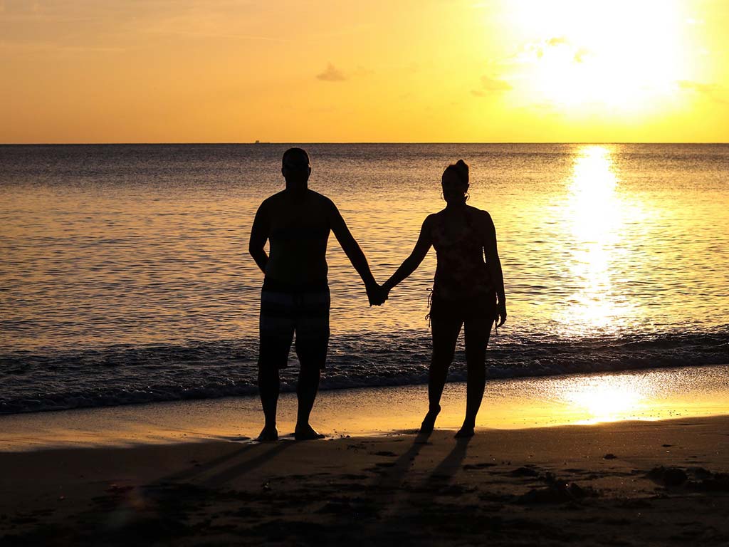 زوجان كالاباش كوف يمشيان على الشاطئ عند غروب الشمس