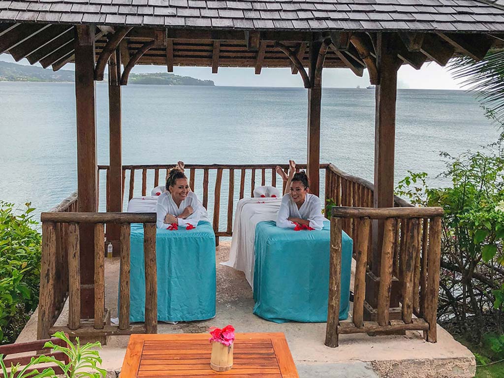 Mujeres de Calabash Cove recostadas en mesas de masaje