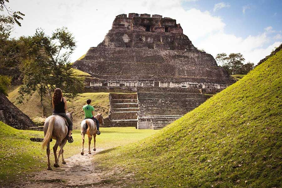 Couple horseback riding at Mayan ruins