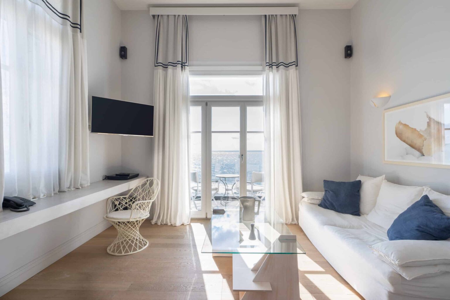 Dexamenes Beachfront Villa’s Suite living area with TV and terrace access