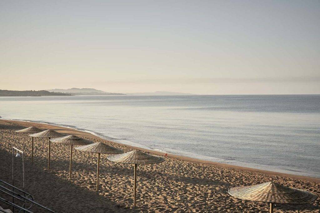 Umbrellas along a private beach at Dexamenes Seaside Hotel in Greece.