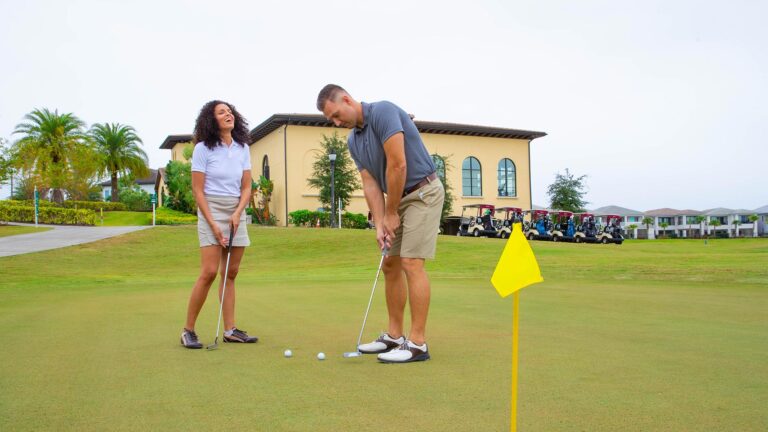 زوجان يلعبان الجولف على ملعب الجولف في Eagle Trace Resort Orlando.