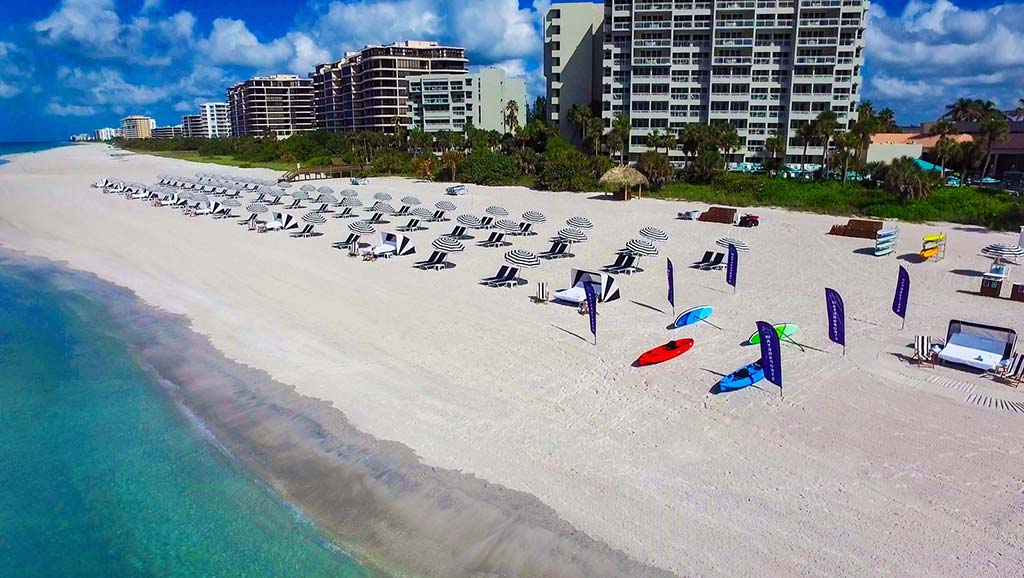 Aerial view of Longboat Key Club area and beach lined with umbrellas.