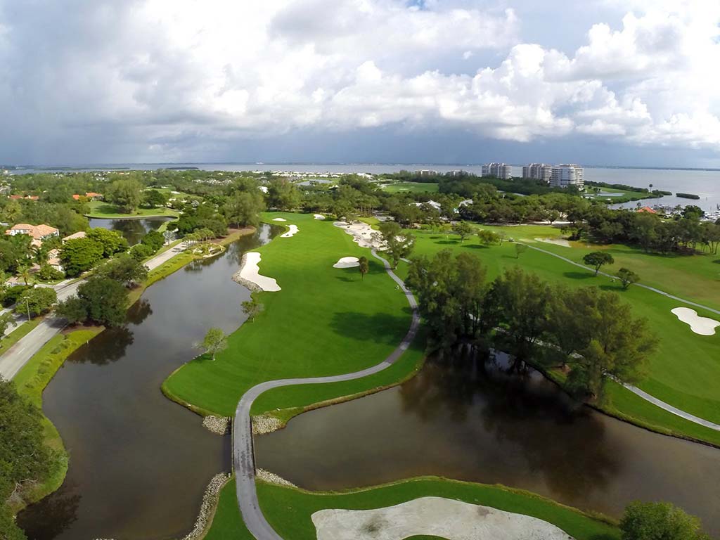 Vista aérea de varios hoyos en el campo de golf con el complejo Longboat Key Club en segundo plano.