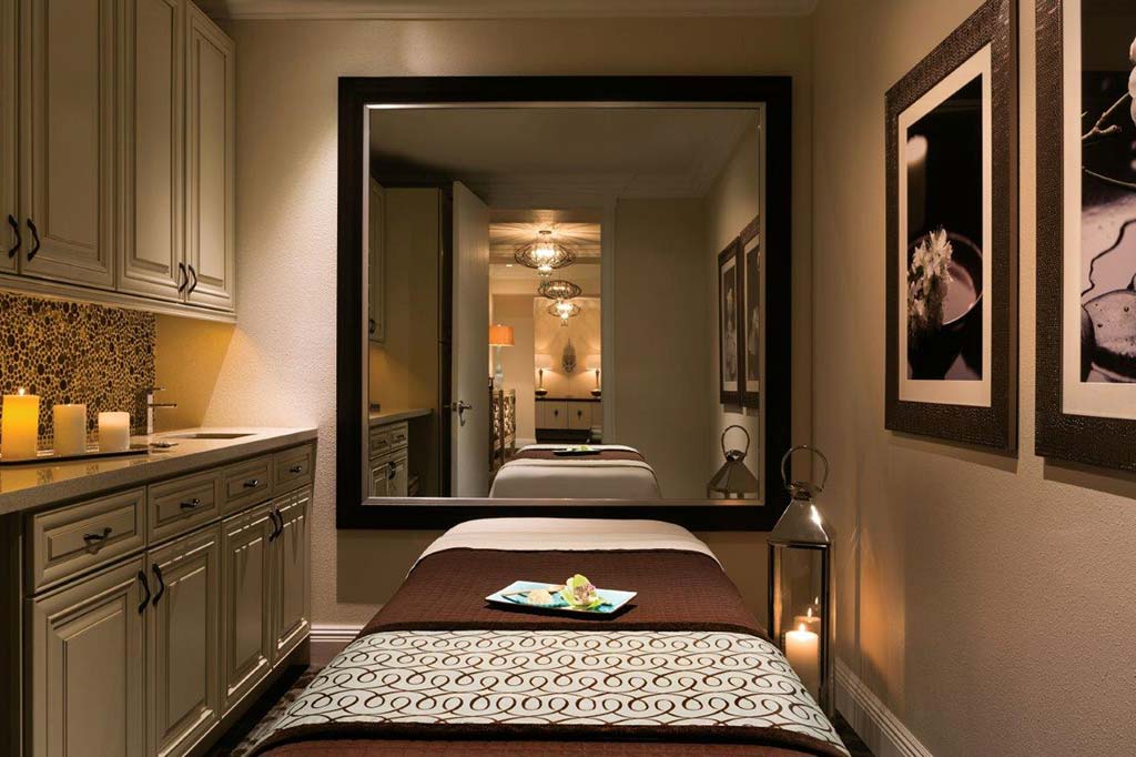 Sala de spa con mesa de masajes y velas preparadas para un masaje relajante.