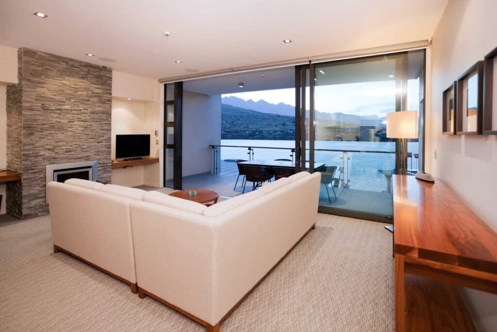 Apartamento ejecutivo de 2 habitaciones con vista al lago, sala de estar con sofá seccional y acceso al balcón