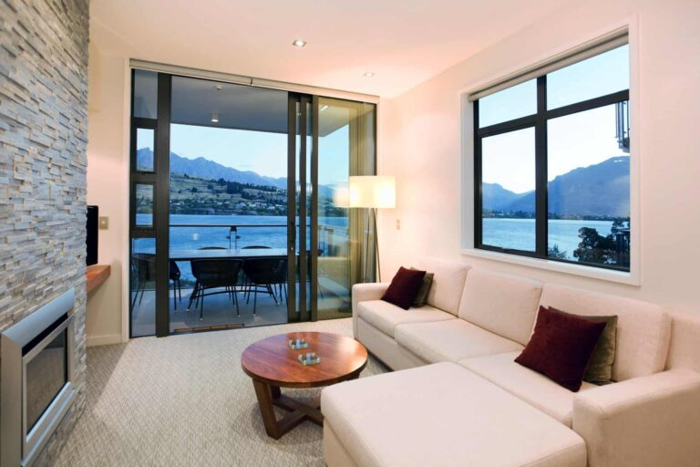 Sala de estar con chimenea y acceso al balcón: Apartamento de 1 dormitorio con vistas al lago