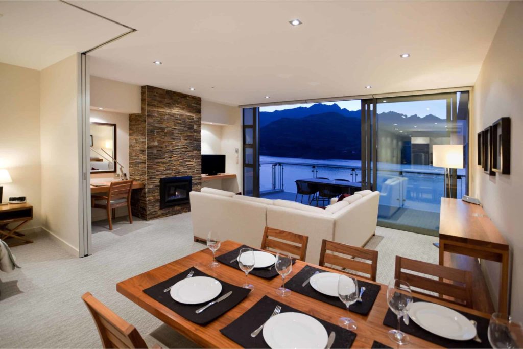 Comedor y sala de estar con balcón y chimenea: Apartamento de 3 habitaciones con vista al lago