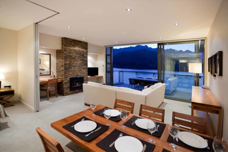 Comedor y sala de estar con balcón y chimenea: Apartamento de 3 habitaciones con vista al lago