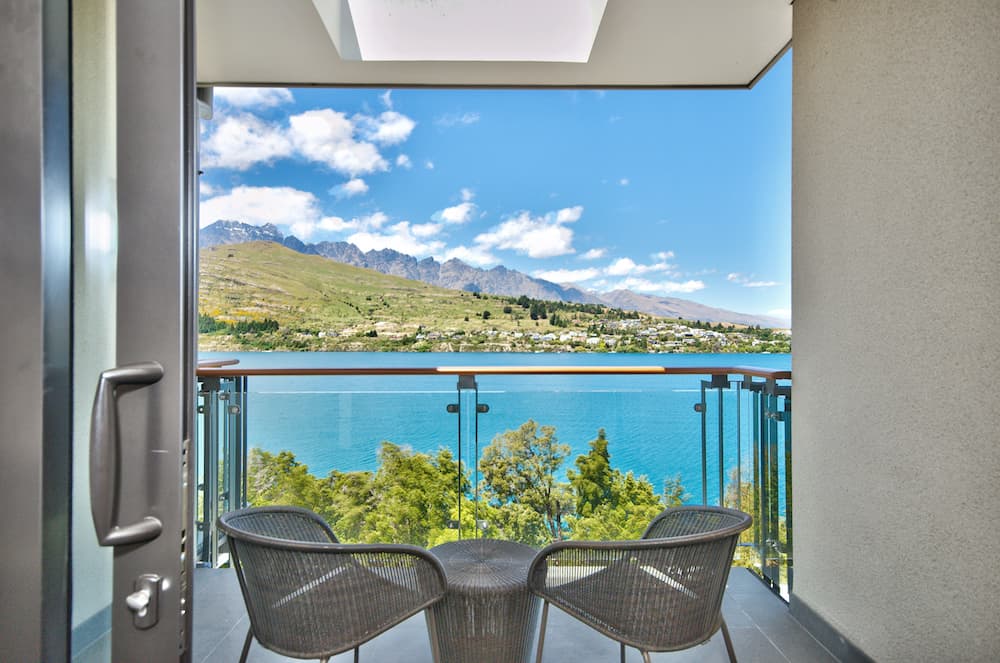 Habitación de hotel con vista al lago Balcón cubierto con sillas y vista al lago