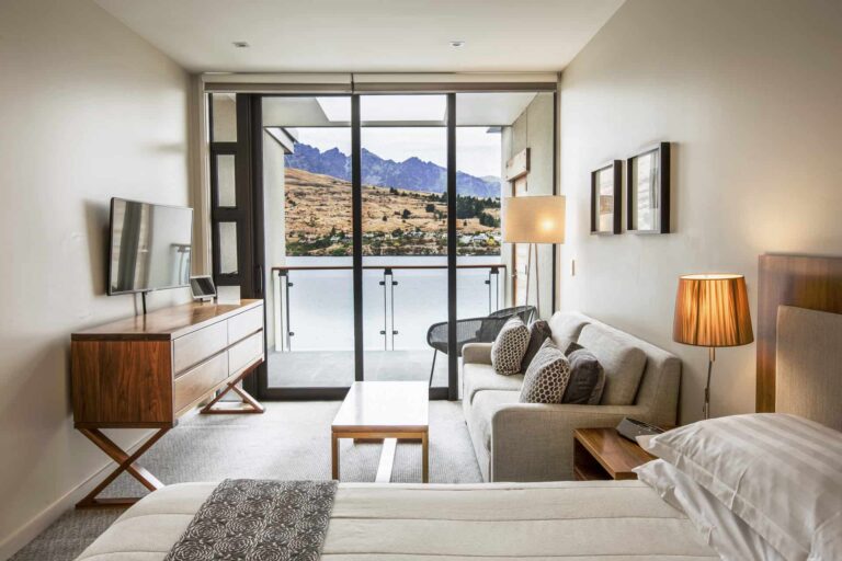 Habitación de hotel con vista al lago con sofá, TV y cama King