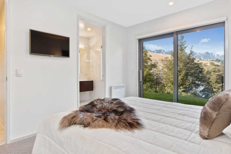 Rees Residence bedroom with mountain view and wall mounted TV