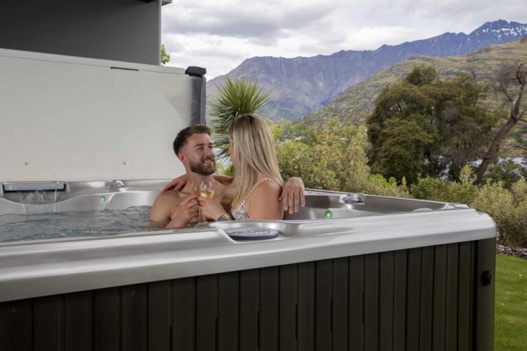 Couple toasting with wine glasses in a Jacuzzi at a Rees Residence