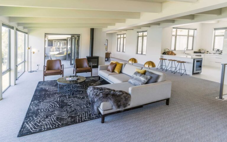 Rees Residence sala de estar y área de cocina con sofá seccional y taburete para sentarse