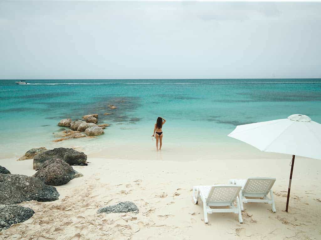 Things to do in Providenciales. Woman standing on a beach looking out into the ocean.