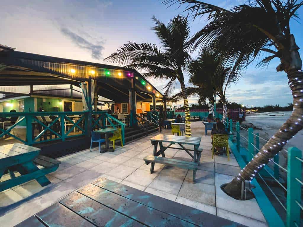 Providenciales Restaurante al aire libre mesas de picnic con palmeras iluminadas junto al mar.