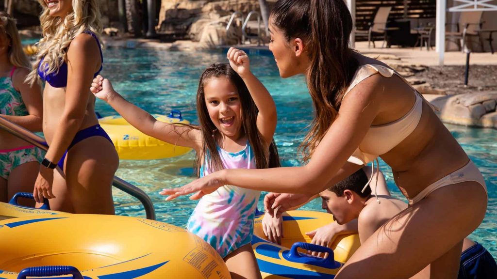 Garota feliz com sua mãe no rio lento no parque aquático Eagle Trace Resort Orlando.