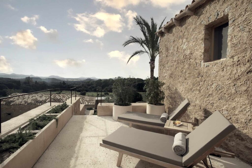 Es Racó d’Artà suite private balcony with sun loungers overlooking the hills of the island of Mallorca, Spain