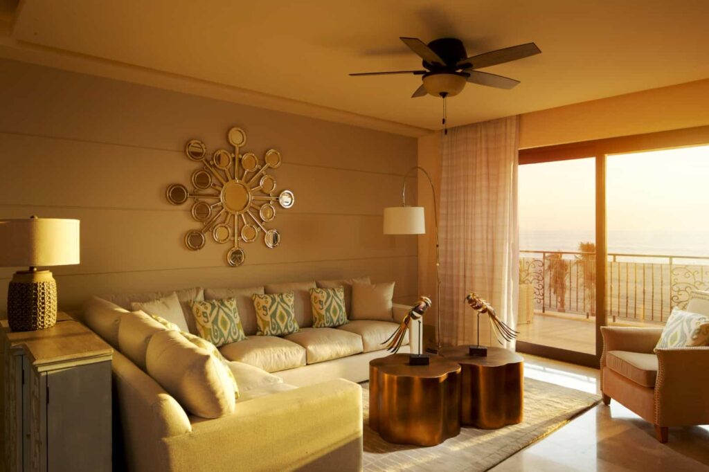 Sala de estar de la Suite Presidencial con sofás, sillón y acceso al balcón con vista al mar