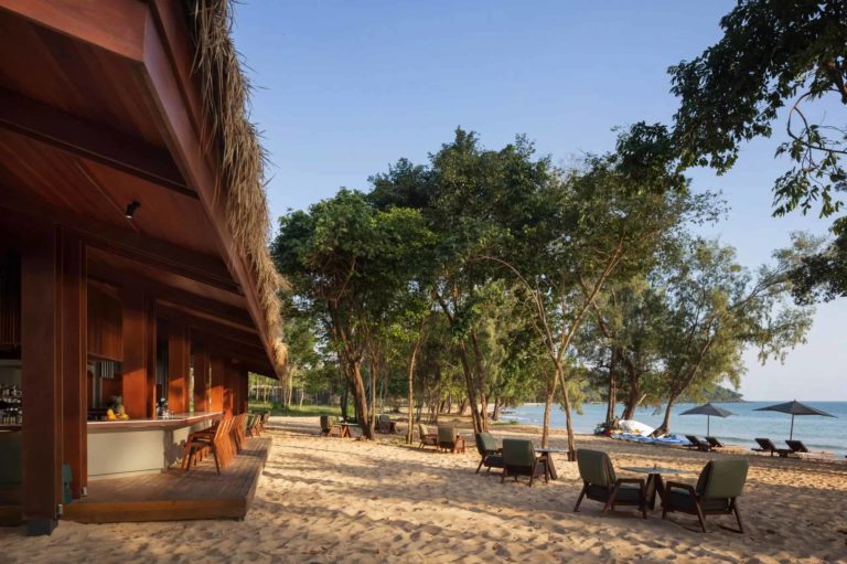 Koh Russey Villas & Resort bar frente al mar y sillas a lo largo de la arena
