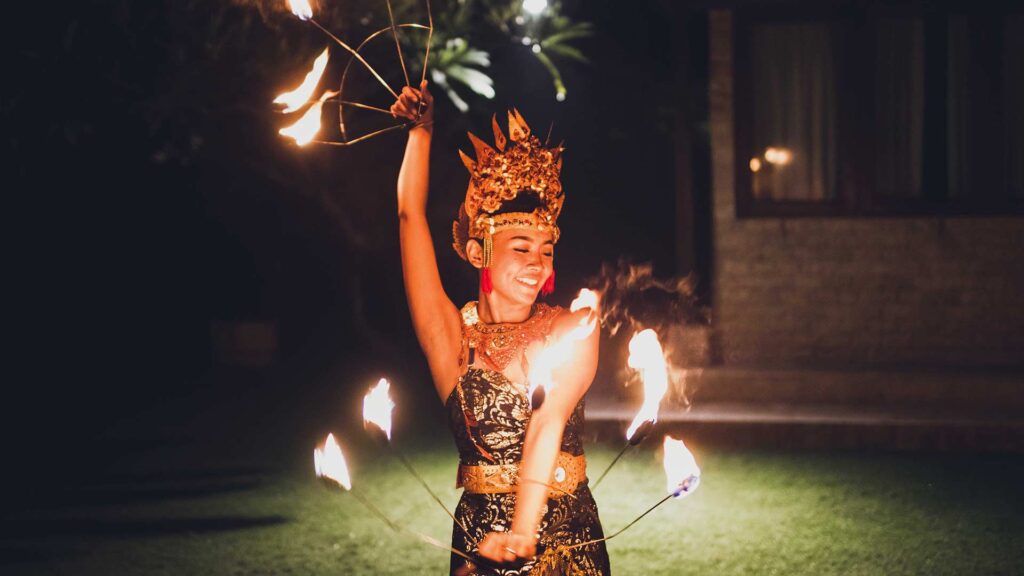 Balinesischer traditioneller Tanz mit Feuershow bei der abendlichen Strandparty.
