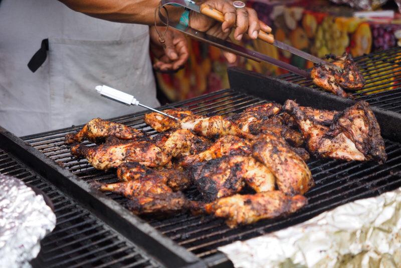 Chef barbequing chicken on a grill
