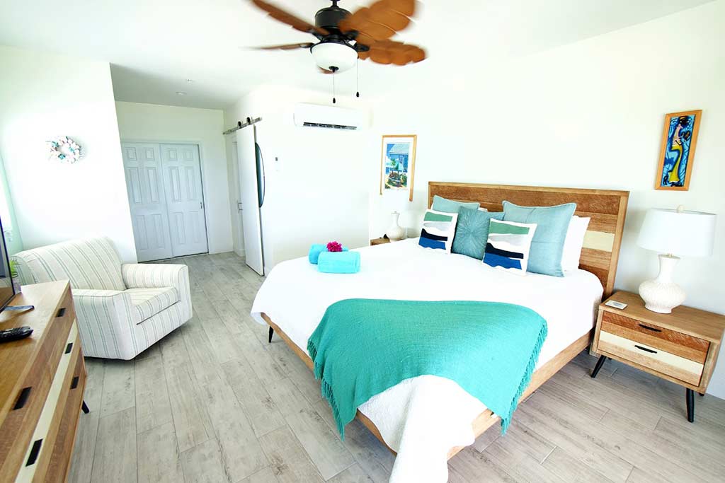 Blue Iguana guest room king bed with end tables and plush chair