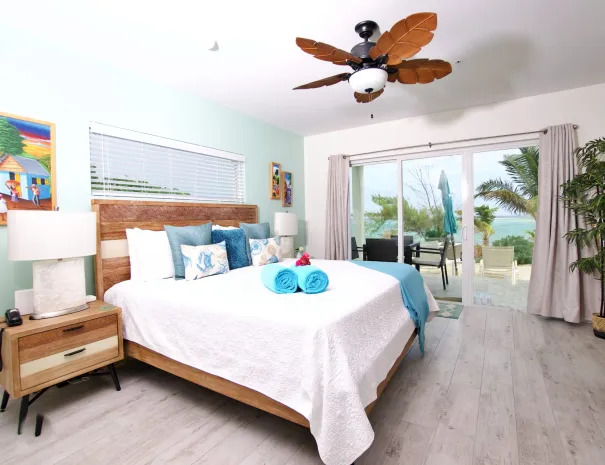 Tropical Breeze guest room king bed with end tables and ceiling fan