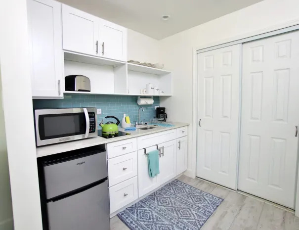 Tropical Breeze guest room kitchenette with mini fridge, microwave, coffee maker, toaster, and tea kettle