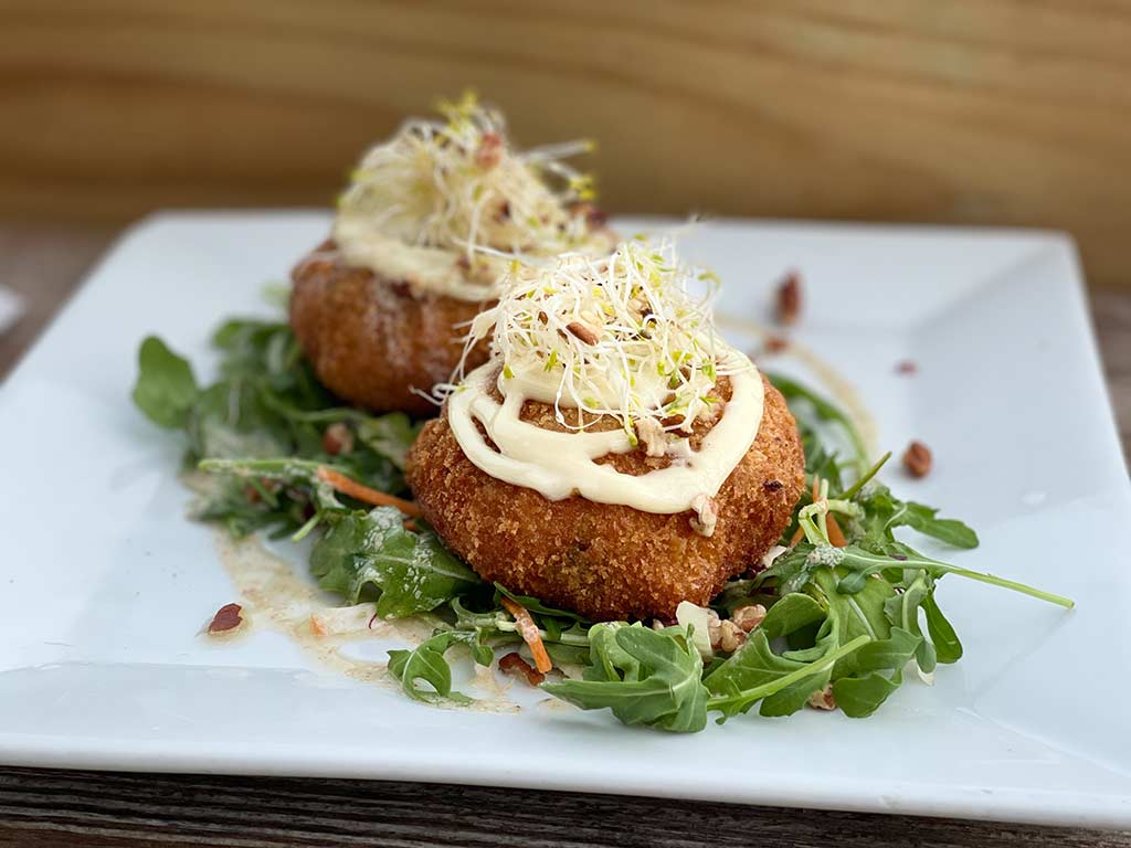 Plated conch fritters over mixed greens.