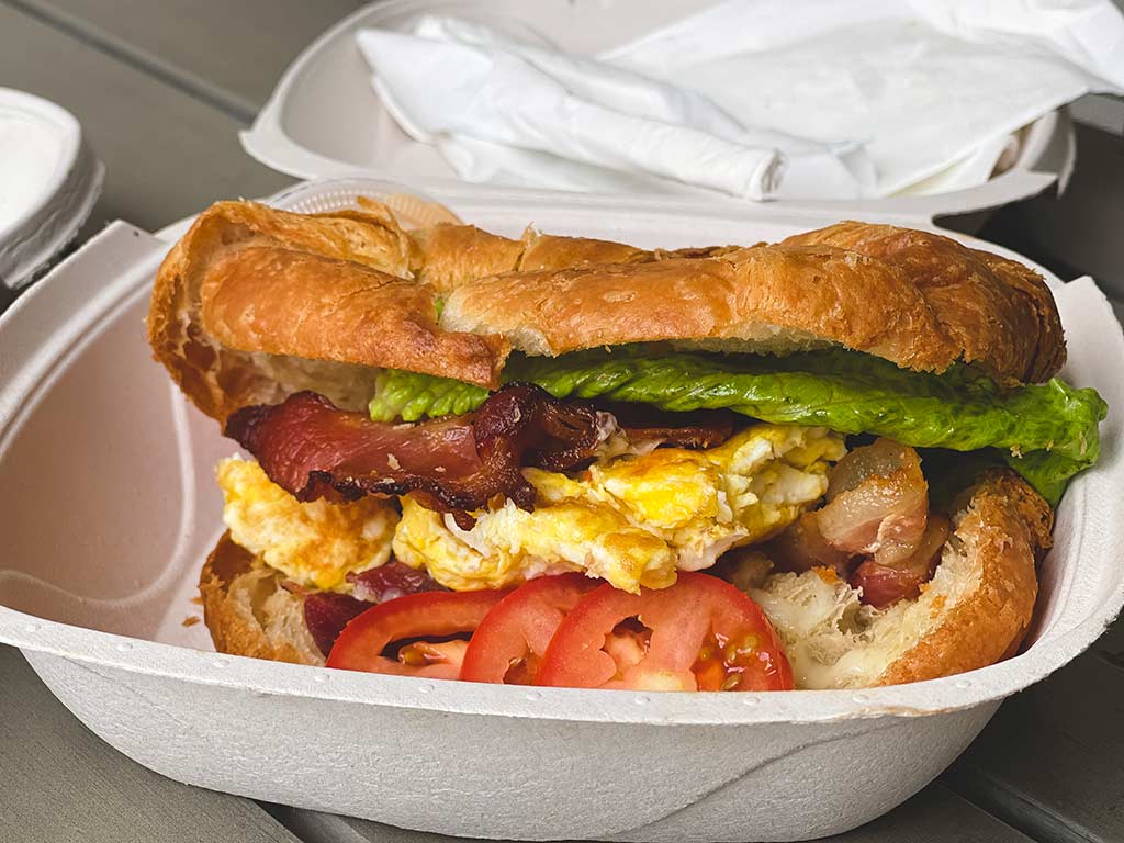 Bacon and egg sandwich in a take out container.