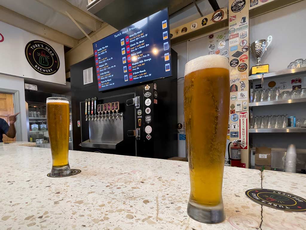 Glasses of beer on a bar countertop at a brewery.