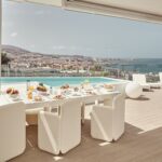 Baobab Suites BB Lounge Club-Esstisch mit Blick auf den Pool und die Küste von Costa Adeje