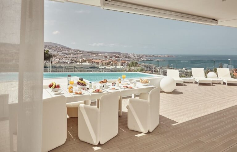 Table à manger Baobab Suites BB Lounge Club avec vue sur la piscine et la côte de Costa Adeje