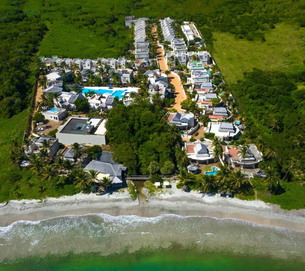 Aerial view of Cap Cove Resort beach, villas, and property