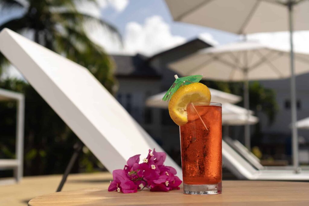 Tropical drink next to a poolside sun lounger