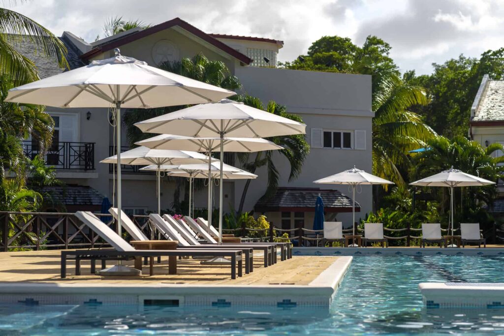 Cap Cove Resort pool, sun loungers, and umbrellas in front of a poolside suite