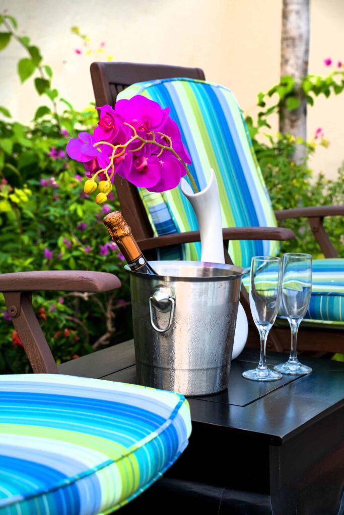 Champán frío y copas en una mesa auxiliar en un patio trasero privado de Cap Cove Resort