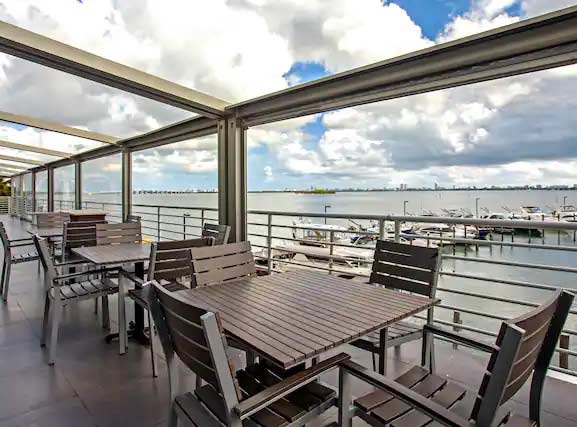 Asientos al aire libre del Grand Hotel Biscaye Bay con vista a un puerto deportivo