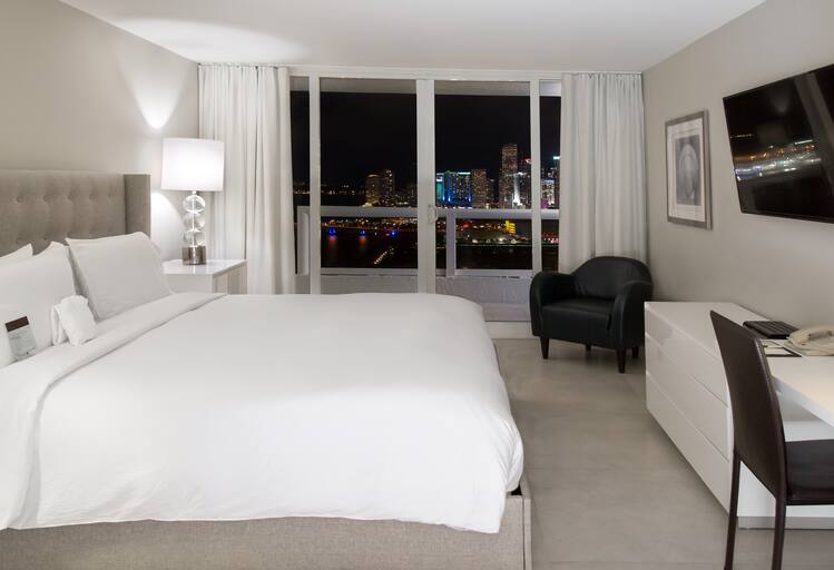 Bedroom with nighttime city view at Grand Hotel Biscayne Bay