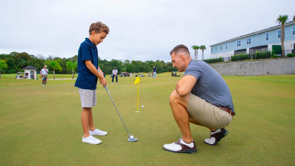 الأب يعلم ابنه كيفية لعب الجولف
