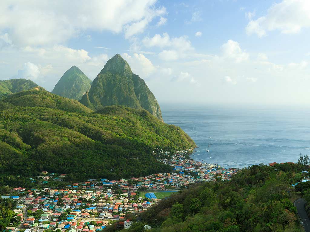 Blick auf ein Dorf mit den Pitons von St. Lucia